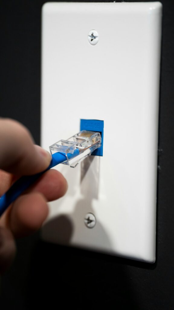 A closeup of an ethernet cable being plugged into a cat 5E port